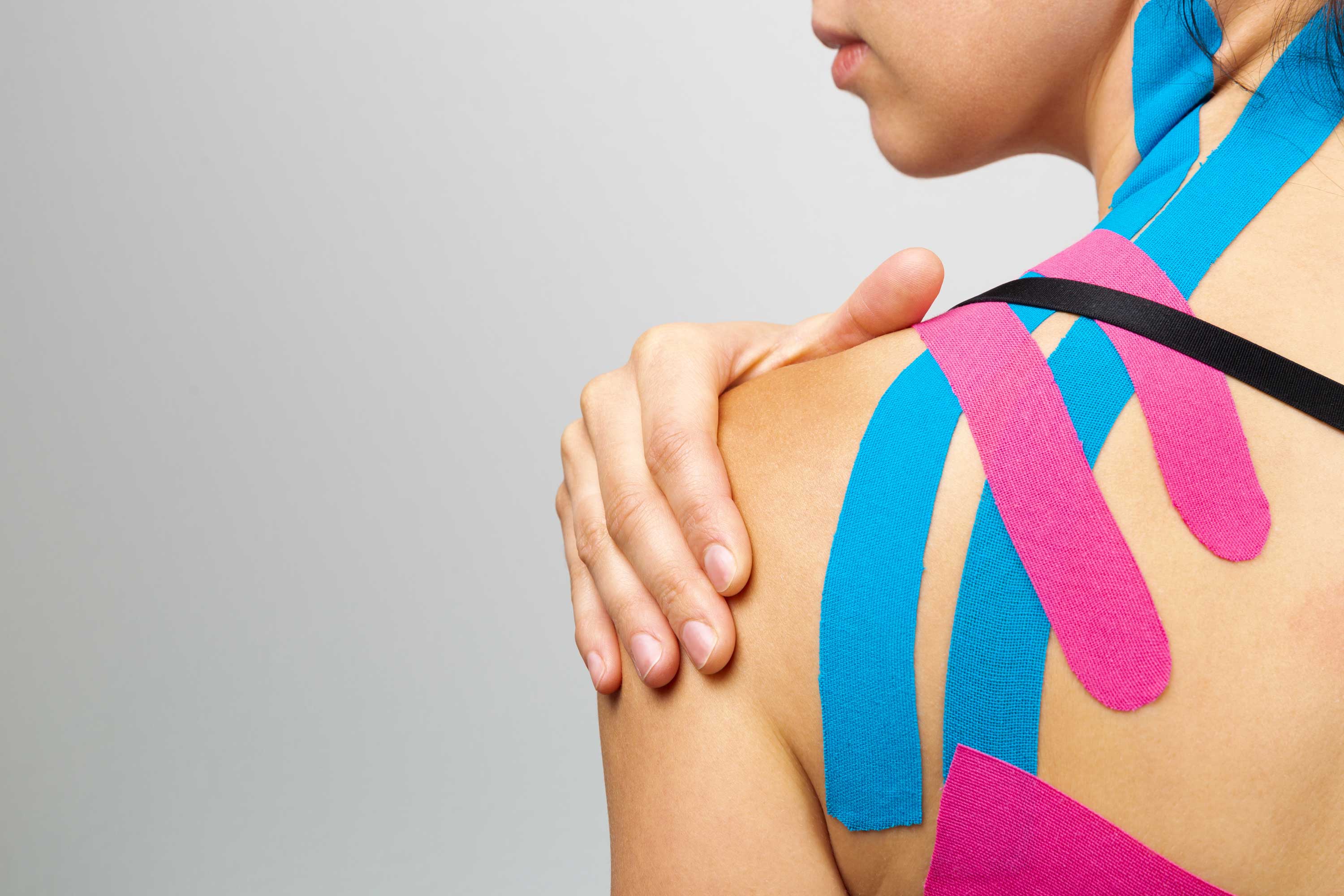 A woman with kinesiology tape on her shoulder